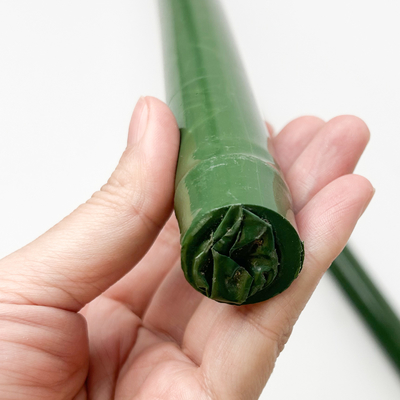 El plástico cubrió el bambú crudo natural postes para las ayudas de las participaciones de la planta de los árboles de los tomates